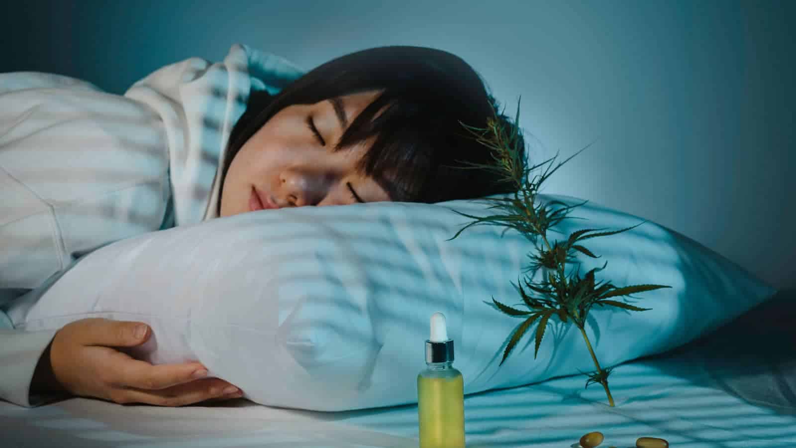 Woman sleeping peacefully with cannabis plant and oil for sleep aid.